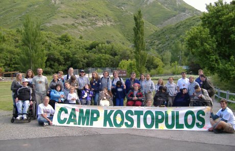 Group holding a Camp Kostopulos banner