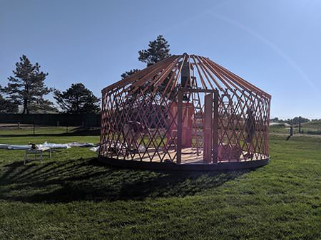 Wooden yurt frame standing in a field