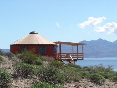 Yurt overlooking water and distant mountains