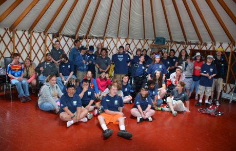 Camp group gathered inside a yurt