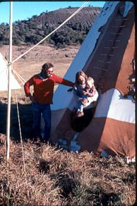 People standing beside a tipi
