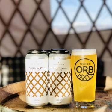 Beverages on a table beside a yurt lattice wall