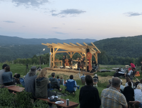 People gathered near a wooden yurt frame