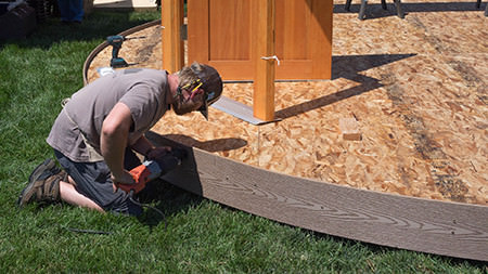 Worker attaching material at a platform edge