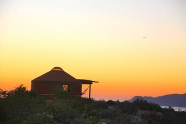 Yurt silhouetted against a sunset