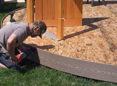 Worker fitting the outer edge of a yurt platform