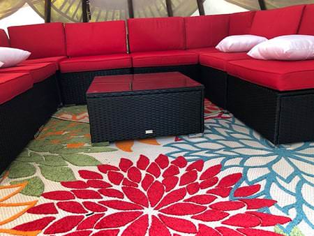 Red sofa and patterned rug inside a tipi