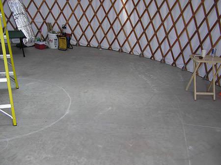 Concrete floor inside a yurt lattice wall