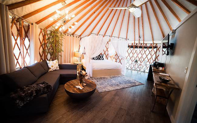 Furnished yurt interior with a bed and sofa