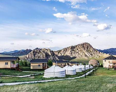 Yurts near lodge buildings in a mountain valley