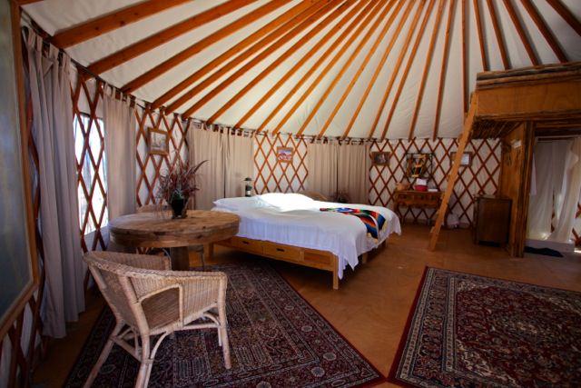 Yurt bedroom with wood flooring