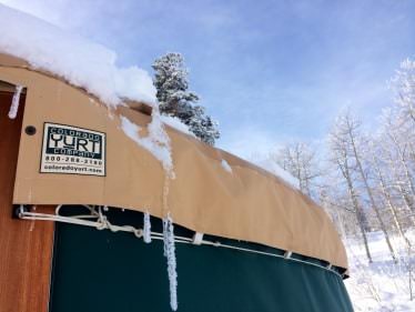 Snow around the wall and roof of a yurt